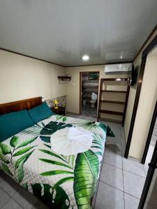 a bedroom with a bed with a green and white comforter at Casa Federico in Quepos