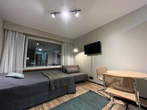 a bedroom with a bed and a table and a window at Northern Lights Center Apartment 2 in Rovaniemi