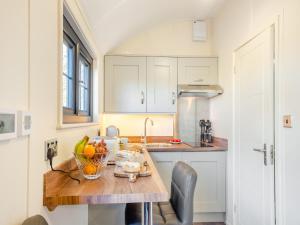 a kitchen with a table with a bowl of fruit on it at The Retreat - Ukc5913 in Bangor-is-y-coed