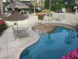a swimming pool with two chairs and an umbrella at Cabo Villa - G3 Punta Arena - 3 Bed 2.5 Bath in Cabo San Lucas