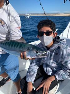 a man in a mask holding a fish on a boat at Cabo Villa - G3 Punta Arena - 3 Bed 2.5 Bath in Cabo San Lucas