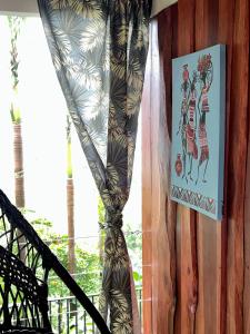 een gordijn aan een muur met een foto van vrouwen bij Casa Federico in Quepos
