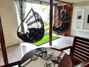 a dining room with two hanging chairs and a table at Casa Federico in Quepos