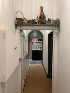 a hallway with a shelf with baskets on top at Luxury flat in Totnes in Totnes