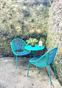 two blue chairs and a table with a potted plant at Luxury flat in Totnes in Totnes