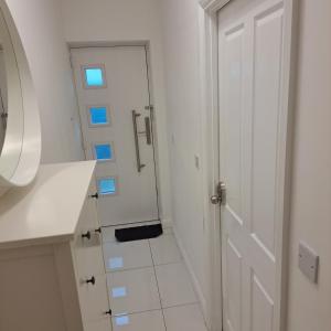 a white bathroom with a door and a mirror at Lovely and Modern Groundfloor 1 Single Bedroom Condo with Netflix, Tea/Coffee/Biscuits in Bristol