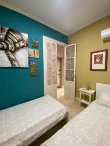 1 dormitorio con 2 camas y pared azul en CHIC e CLASSIC, en Alicante