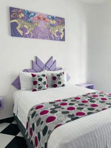 a bedroom with a bed with a black and white comforter at WINDAY HOTEL - Cerca 5a Avenida in Playa del Carmen