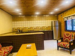 a kitchen with a counter and a table and chairs at Green House in Zūbiyā