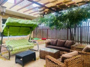 a patio with a couch and chairs and a table at Green House in Zūbiyā