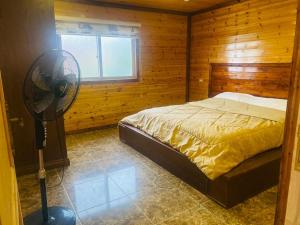 sypialnia z łóżkiem i wentylatorem w pokoju w obiekcie Green House w mieście Zūbiyā