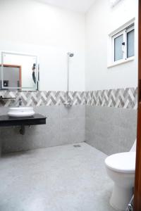 ein Badezimmer mit einem WC, einem Waschbecken und einem Spiegel in der Unterkunft Hotel Grand Lahore in Lahore