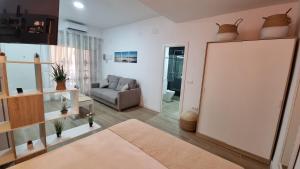 sala de estar con espejo y sofá en Vivienda Turística Playa El Portil, en El Portil