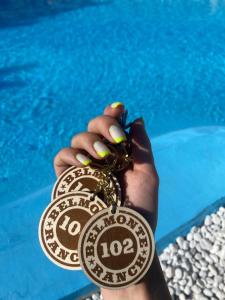 Eine Person, die vor einem Pool eine Medaille hält. in der Unterkunft BELMONTE RANCH in Belmonte Castello