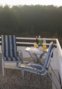 una mesa y 2 sillas sentadas en un balcón en Frauenpreiß Ferienwohnungen, en Cuxhaven