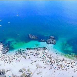 Cabañas Aquila D'Arroscia في باهيا انغليسا: اطلالة جوية على شاطئ فيه ناس في الماء