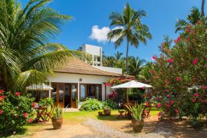 a house with a garden with flowers and trees at Pousada San Giovanni in Japaratinga