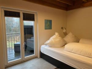 a bedroom with two beds and a sliding glass door at Gästehaus Sille in Morsbach - Holpe in Morsbach