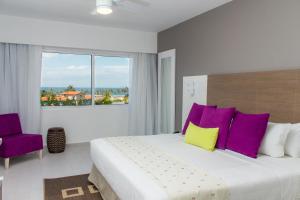 ein Schlafzimmer mit einem großen Bett mit lila und gelben Kissen in der Unterkunft LD Plus in La Mira