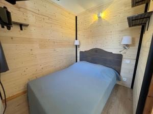a small room with a bed in a wooden wall at Appartement Lanslevillard, 2 pièces, 4 personnes - FR-1-508-23 in Lanslevillard