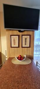 a bowl of fruit on a counter with a television at Apartamentai pas Danutę in Prienai