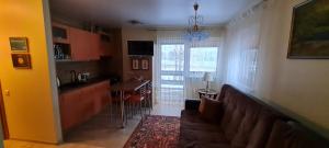 a living room with a couch and a kitchen with a table at Apartamentai pas Danutę in Prienai