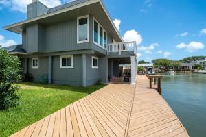 a house with a dock next to a body of water at Edgewater Escape in Rockport
