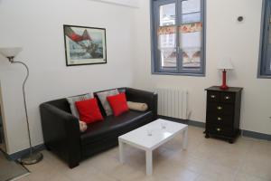 sala de estar con sofá negro y mesa blanca en Appartement du Port de Honfleur, en Honfleur