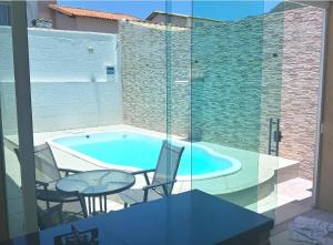 a patio with a swimming pool and a table and chairs at Casa Piscina em Condomínio 5min Praia ITACOATIARA. in Niterói