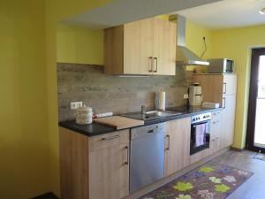 a kitchen with wooden cabinets and a sink at Ferienwohnung Zuckerberg in Saarburg