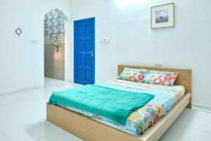 a bedroom with a bed with a blue door at Salem Fish Guest House in Al Ḩadd