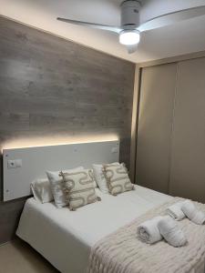 - une chambre avec un lit blanc et un mur en bois dans l'établissement PUERTO BANUS FORTUNA Suite, à Marbella
