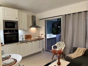 Il dispose d'une cuisine et d'un salon avec un canapé et une table. dans l'établissement PUERTO BANUS FORTUNA Suite, à Marbella