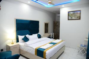 1 dormitorio con 1 cama grande y techo azul en Hotel Grand Lahore, en Lahore