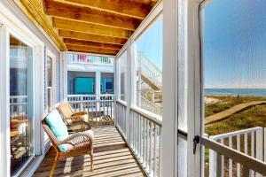een veranda met een schommelstoel en uitzicht op de oceaan bij Happy Days in St. George Island