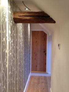 a hallway with a wall of wallpaper and a wooden ceiling at Hunger Barn in Norwell