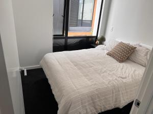 a bed in a small room with a window at Stylish 2 bedrooms townhouse in central Wellington in Wellington