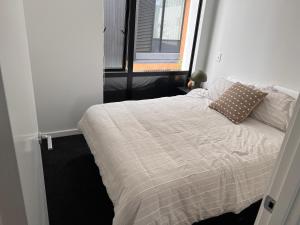 Cama en habitación pequeña con ventana en Stylish 2 bedrooms townhouse in central Wellington en Wellington