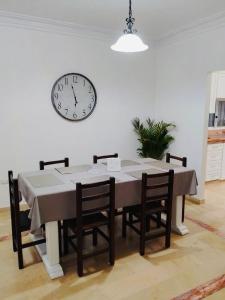 a dining room table with chairs and a clock on the wall at Spacious 2-Bedroom Condo in Bellavista, Guayaquil in Guayaquil