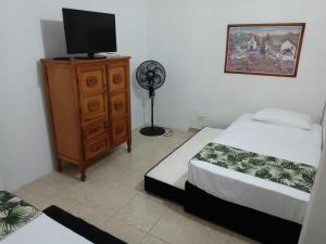 a bedroom with two beds and a tv on a dresser at coliving el jardín de Envigado in Envigado