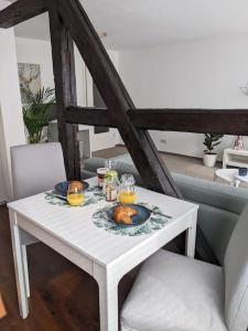 a white table with a plate of food on it at Schlossblick - Modernes & zentrales Apartment mit Balkon und Arbeitsplatz in Schwerin