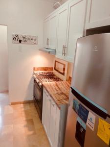 cocina con armarios blancos y nevera de acero inoxidable en Spacious 2-Bedroom Condo in Bellavista, Guayaquil en Guayaquil