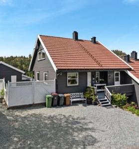 una casa negra con techo rojo y entrada en Sjarmerende familievennlig hus med 2 soverom en Kristiansand