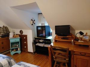 a bedroom with a desk with a computer and a tv at Refuge du Poète in Longueuil