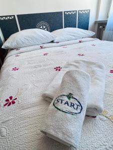 a bed with white towels and flowers on it at Ośrodek Wypoczynkowy Start in Zakopane