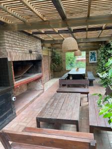 a patio with benches and a table and a fireplace at Amplia, 4 dormitorios y piscina climatizada in Punta del Este