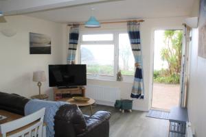 a living room with a couch and a tv at Lobster Pot - Mount Brioni in Downderry