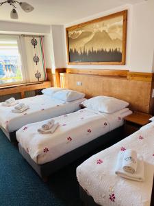 una habitación de hotel con 3 camas y un cuadro en la pared en Ośrodek Wypoczynkowy Start, en Zakopane