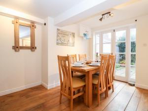 a dining room with a wooden table and chairs at 4 East Green, Southwold in Southwold