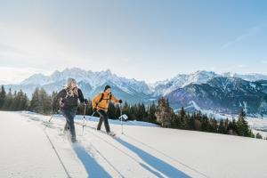 two people cross country skiing on a snowy mountain at Villa Fauster Pustrabase in Villabassa